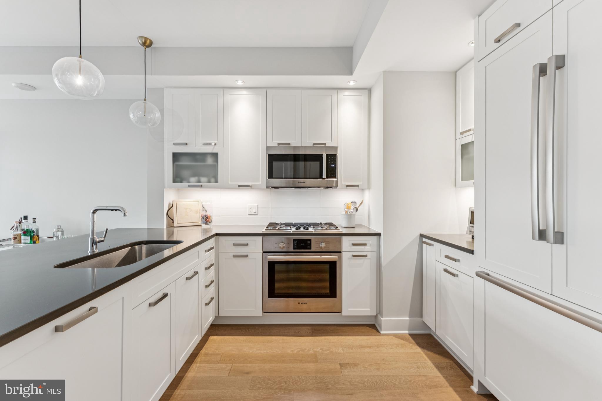 4960 Fairmont Avenue, Unit 904 Bethesda, MD 20814 - Photo 4 of 20 a kitchen with stainless steel appliances a stove a sink and a microwave