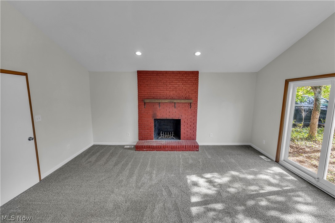 2540 Charney Road University Heights, OH 44118 - Photo 8 of 44 Living space with a red brick fireplace and hearth, a rustic wood mantel, recessed ceiling lighting, and grey patterned carpeting