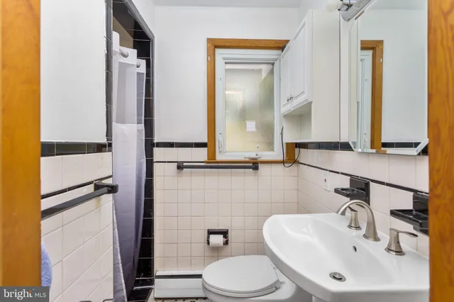 a bathroom with a sink a toilet and mirror