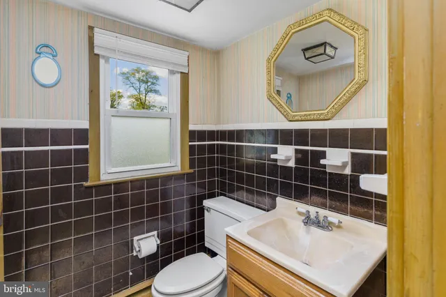 a bathroom with a sink toilet and a mirror