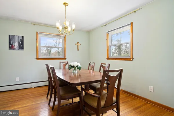 a dining room with furniture a chandelier and wooden floor