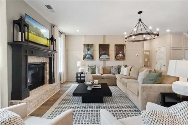 a kitchen with stainless steel appliances a dining table chairs refrigerator and microwave