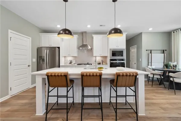 a kitchen with a table chairs refrigerator and microwave