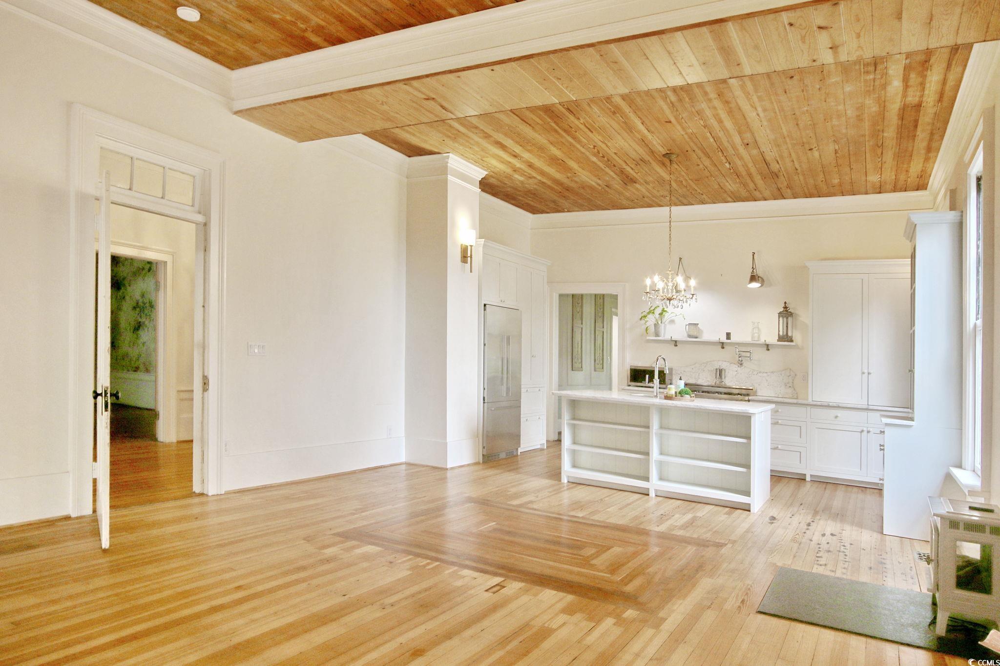 100 Northeast Ct Street Marion, SC 29571 - Photo 24 of 40 Unfurnished living room featuring wood ceiling, a chandelier, crown molding, and light wood-style flooring