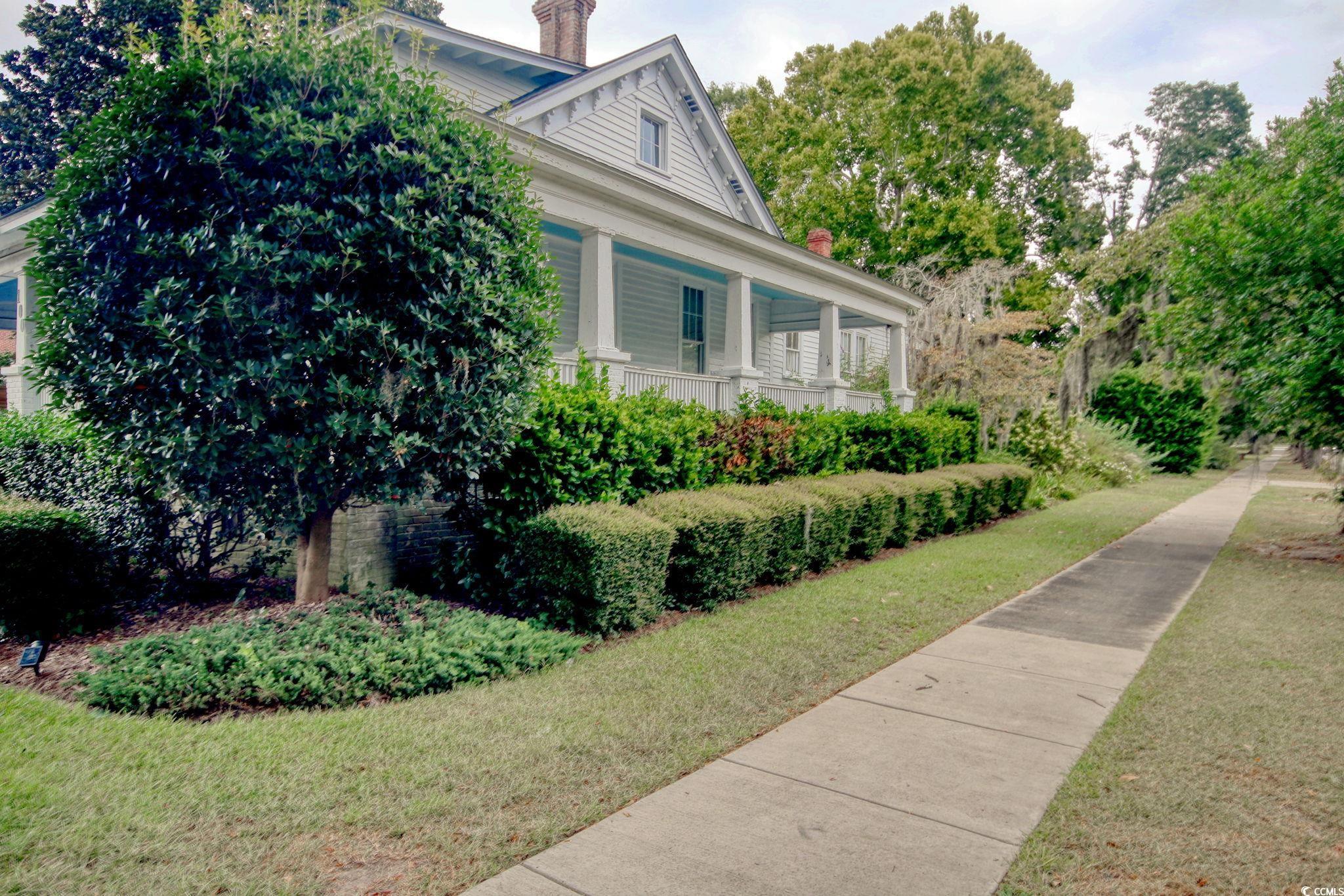 100 Northeast Ct Street Marion, SC 29571 - Photo 3 of 40 View of property exterior featuring a large porch, a chimney, and a lawn