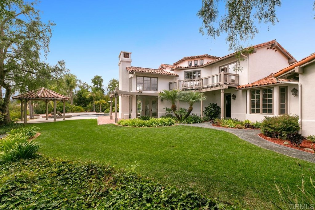 14910 Rancho Nuevo Del Mar, CA 92014 - Photo 43 of 54 a view of a white house next to a yard with big trees