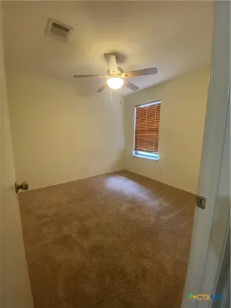 en empty room with windows and fan