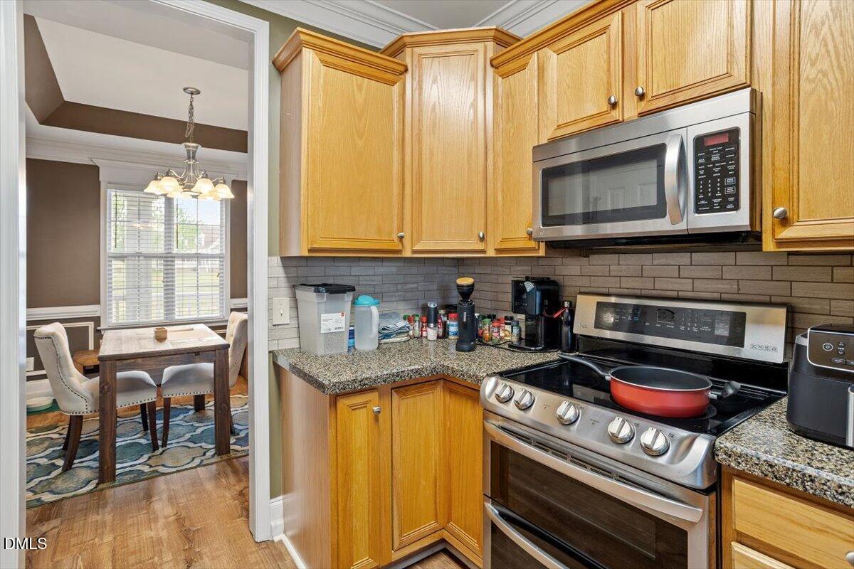 118 Victory Circle Willow Spring, NC 27592 - Photo 21 of 42 a kitchen with stainless steel appliances granite countertop a stove a sink and a microwave