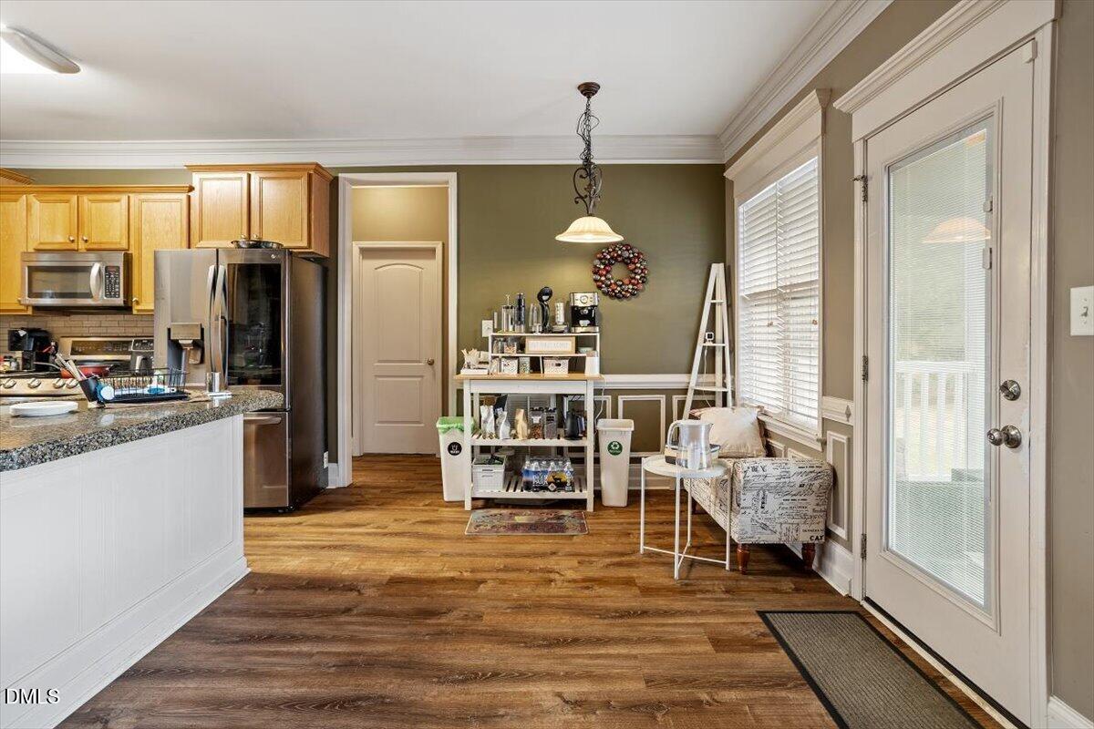 118 Victory Circle Willow Spring, NC 27592 - Photo 24 of 42 a kitchen view with stainless steel appliances kitchen island granite countertop a refrigerator a stove and a dining table with wooden floor