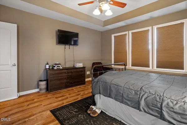 a bedroom with a bed and wooden floor