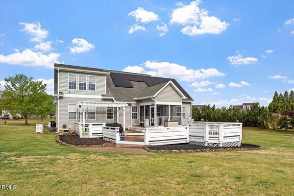 a white house covered with tall trees