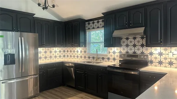 a kitchen with granite countertop stainless steel appliances and wooden cabinets