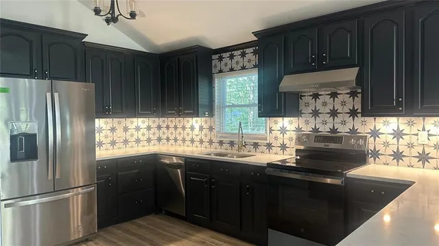 a kitchen with granite countertop stainless steel appliances and wooden cabinets