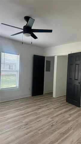 an empty room with wooden floor and windows