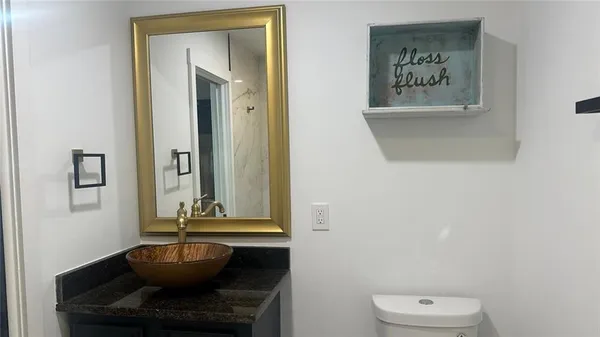 a bathroom with a granite countertop sink and a mirror