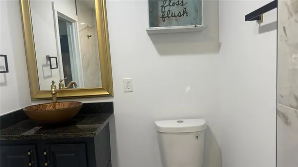 a bathroom with a granite countertop sink and a mirror