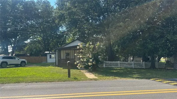 a front view of a house with a garden and trees
