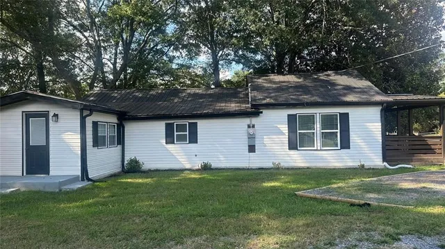 a view of a house with a yard and sitting area