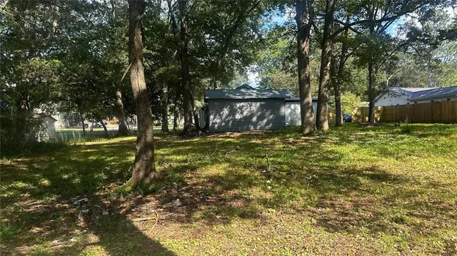 a front view of house with yard and trees in the background