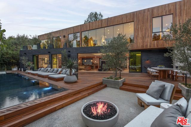 a view of a patio with couches table and chairs and potted plants