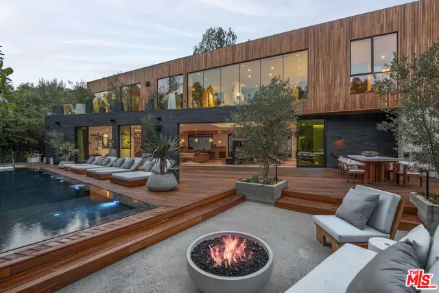 a view of a patio with couches table and chairs and potted plants