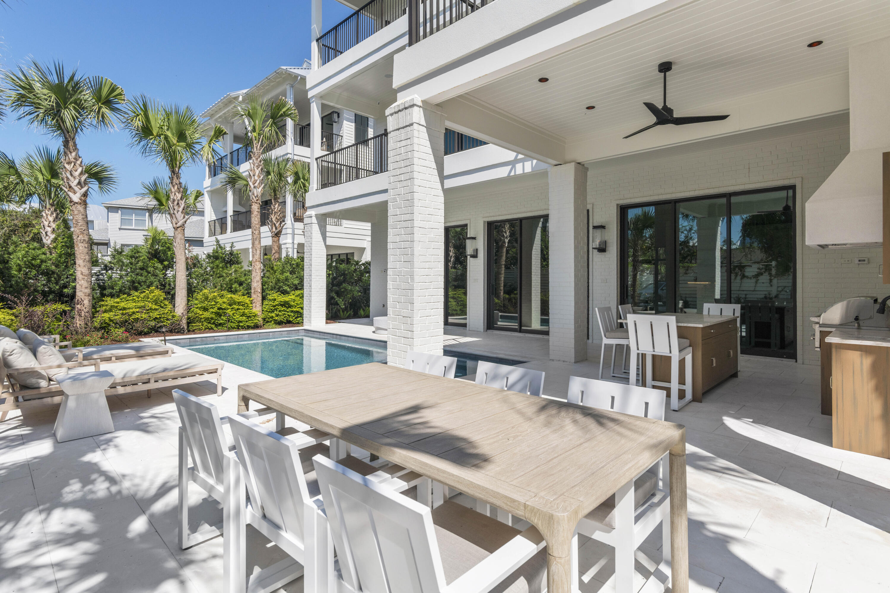 140 South Wall Street Inlet Beach, FL 32461 - Photo 11 of 82 a view of a patio with couches table and chairs potted plants and palm trees