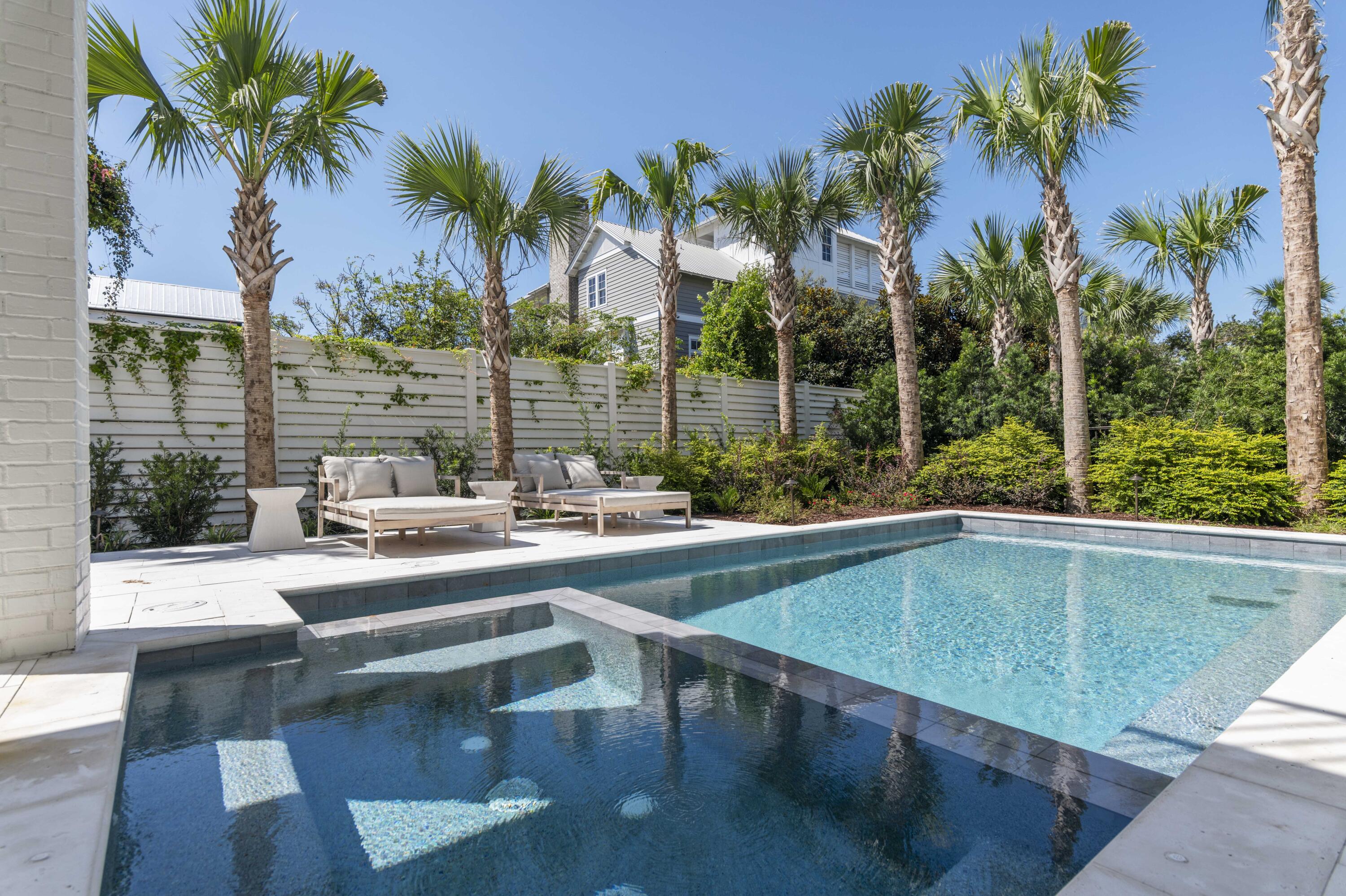 140 South Wall Street Inlet Beach, FL 32461 - Photo 4 of 82 a view of a swimming pool with a lawn chairs under palm trees