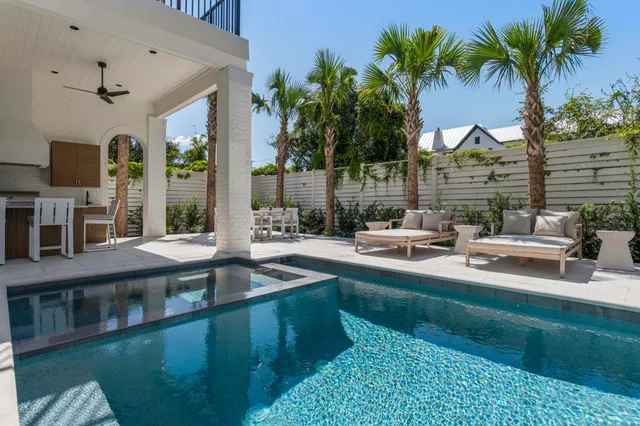 a view of a house with a swimming pool and sitting area