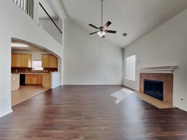 a view of an empty room with a kitchen and a fireplace