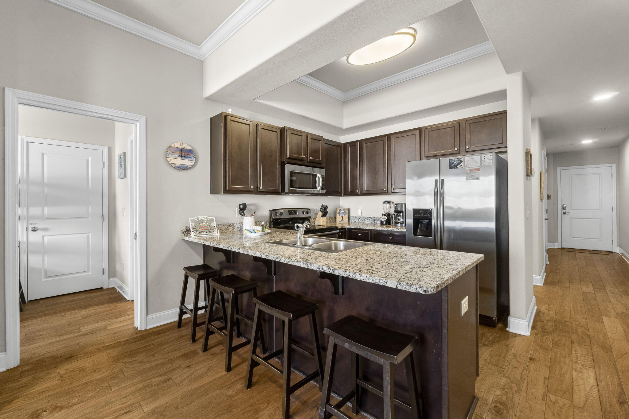 732 Scenic Gulf Drive, Unit E304 Destin, FL 32550 - Photo 15 of 34 a kitchen with stainless steel appliances granite countertop a refrigerator a stove a sink a dining table and chairs
