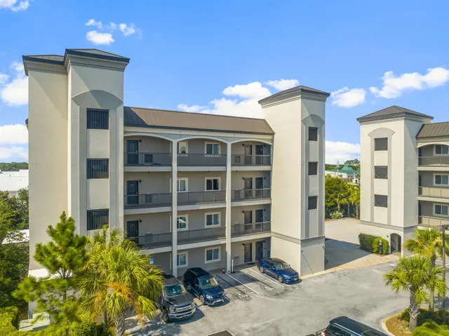 a front view of a building with a garden and plants