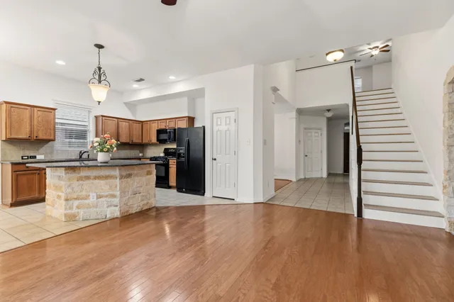 a kitchen with granite countertop a stove a sink and a refrigerator