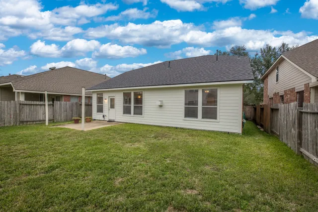 a view of a big house with a yard and large trees