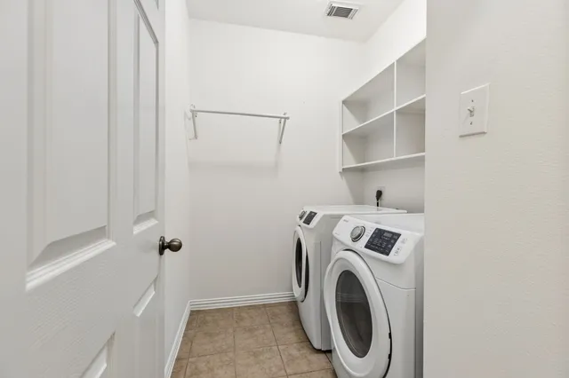 a view of an empty room with a kitchen and a fireplace