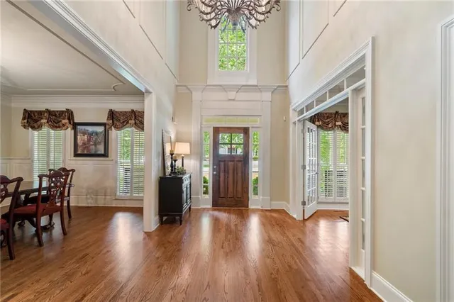 a dining room with furniture a large window and wooden floor