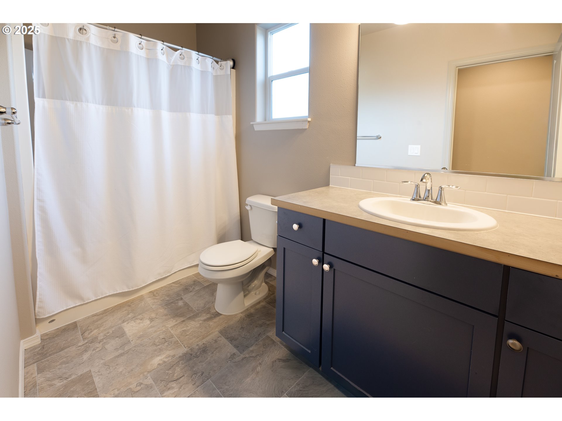 792 South 52nd Place Springfield, OR 97478 - Photo 16 of 45 a bathroom with a sink a toilet a mirror and shower curtain
