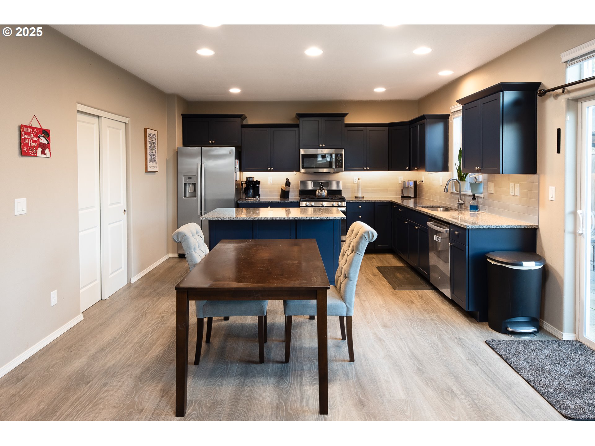 792 South 52nd Place Springfield, OR 97478 - Photo 7 of 45 a living room with stainless steel appliances kitchen island a table chairs and a dining table with wooden floor