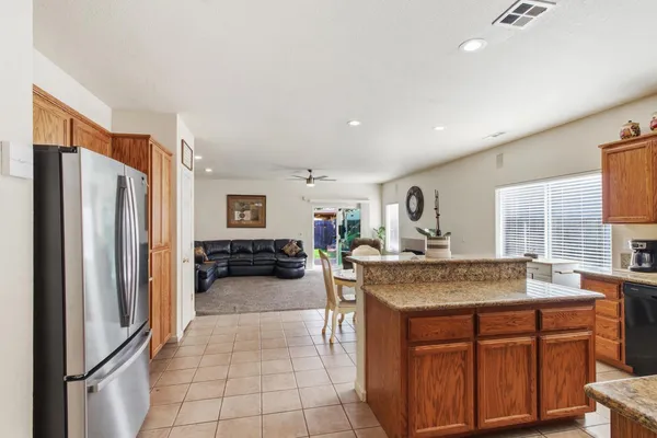 a kitchen with stainless steel appliances granite countertop a stove refrigerator and cabinets