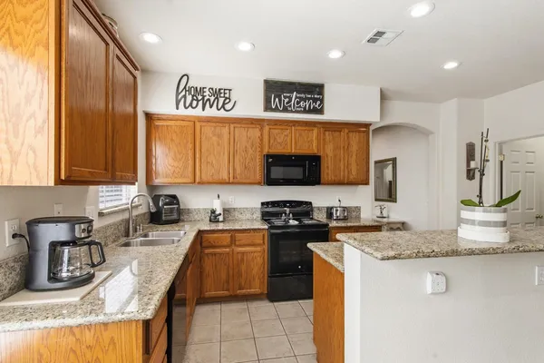 a kitchen with stainless steel appliances granite countertop a sink stove and refrigerator
