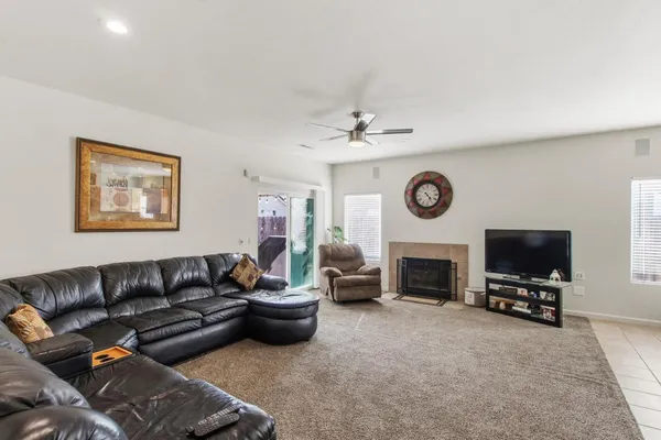 a living room with furniture a flat screen tv and a fireplace