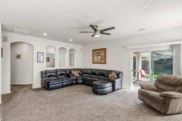 a living room with furniture ceiling fan and a window