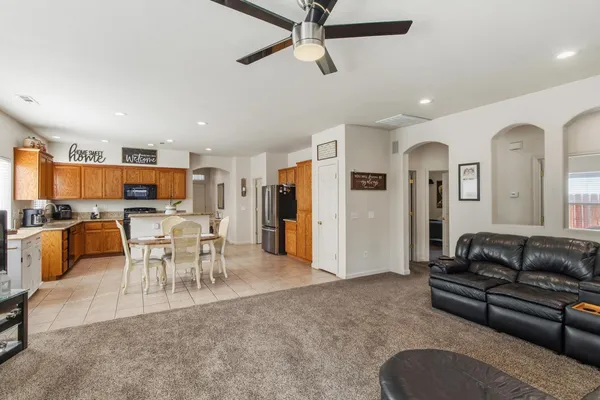 a living room with furniture kitchen view and a large window