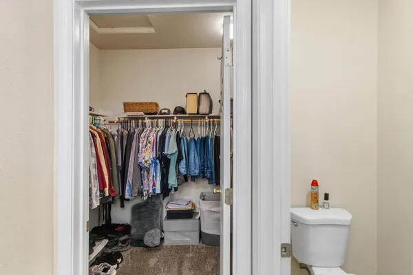 a view of walk in closet with clothes and shoes