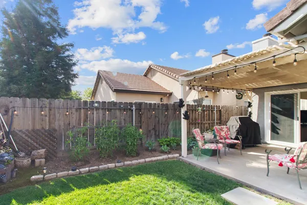 a view of a patio with table and chairs with wooden fence and plants
