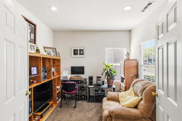 a living room with furniture a bookshelf and a flat screen tv
