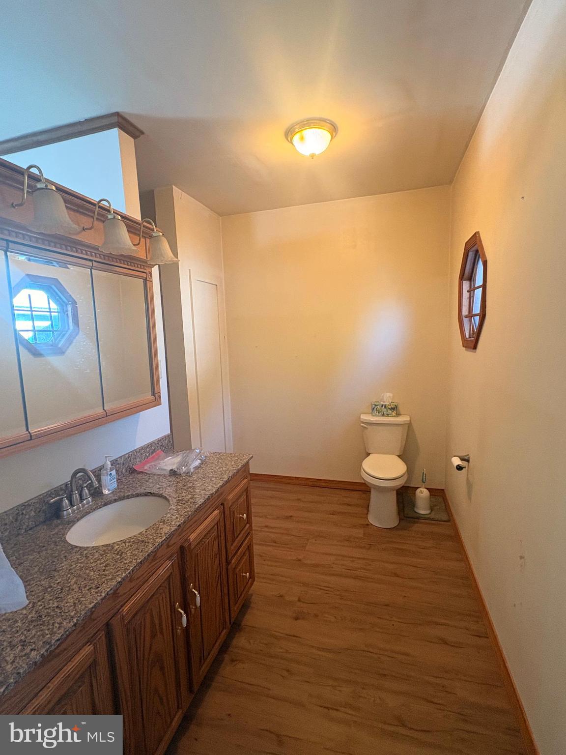 3189 Powells Valley Road Halifax, PA 17032 - Photo 25 of 44 a bathroom with a granite countertop sink a toilet and a mirror