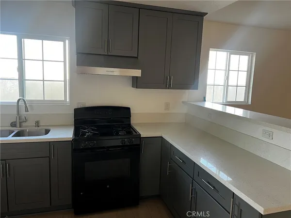 a kitchen with a sink stove and cabinets