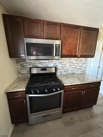 a kitchen with granite countertop cabinets and steel stainless steel appliances
