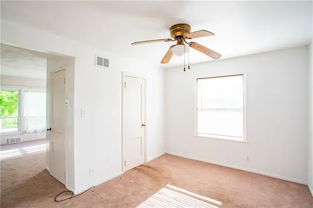 a view of a room with a ceiling fan and a window