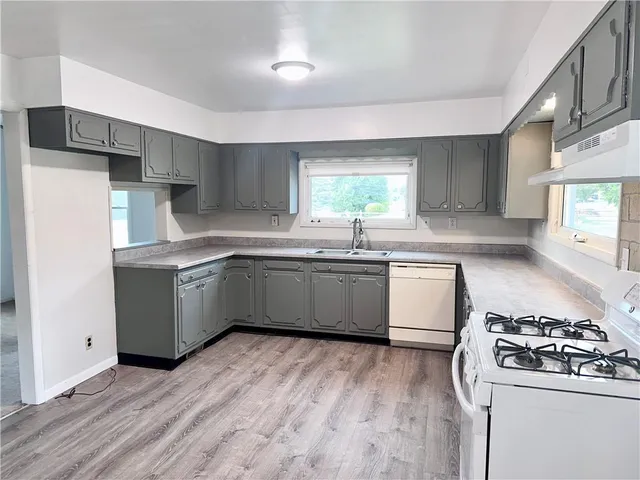 a kitchen with a sink a stove a refrigerator and a window